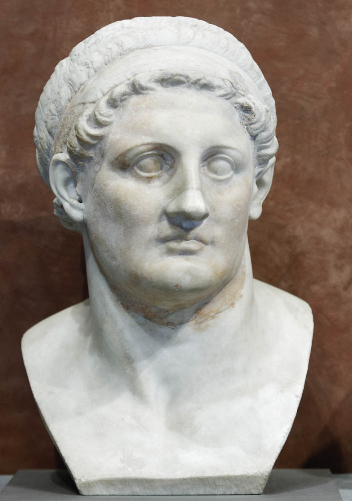 A bust of Ptolemy I made of smooth stone. The sculpture is detailed.