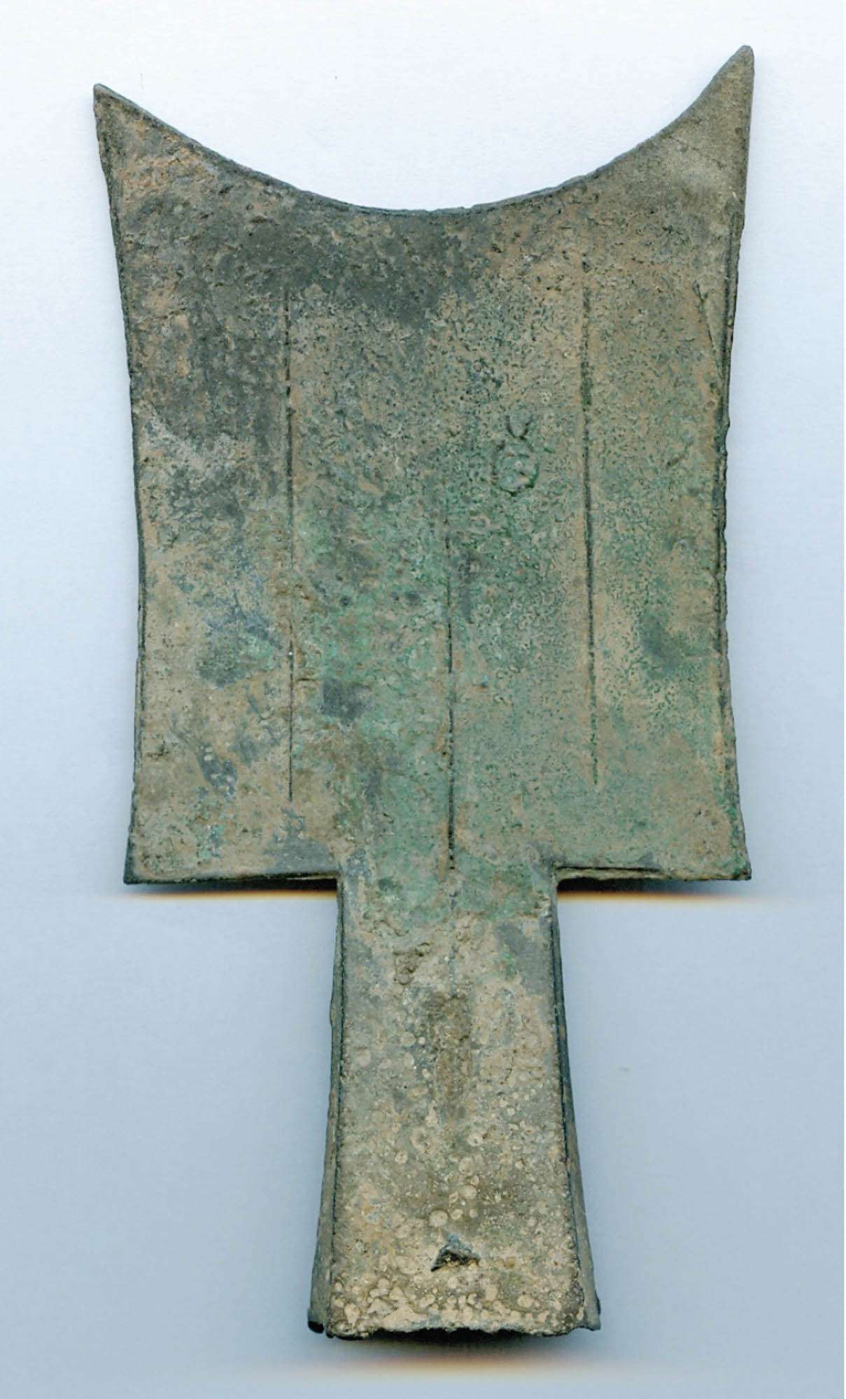 Spade coin used as money. The coin is shaped almost like a flattened shovel, with a slimmer handle and larger rectangular paddle that comes to two points and has a curved edge.