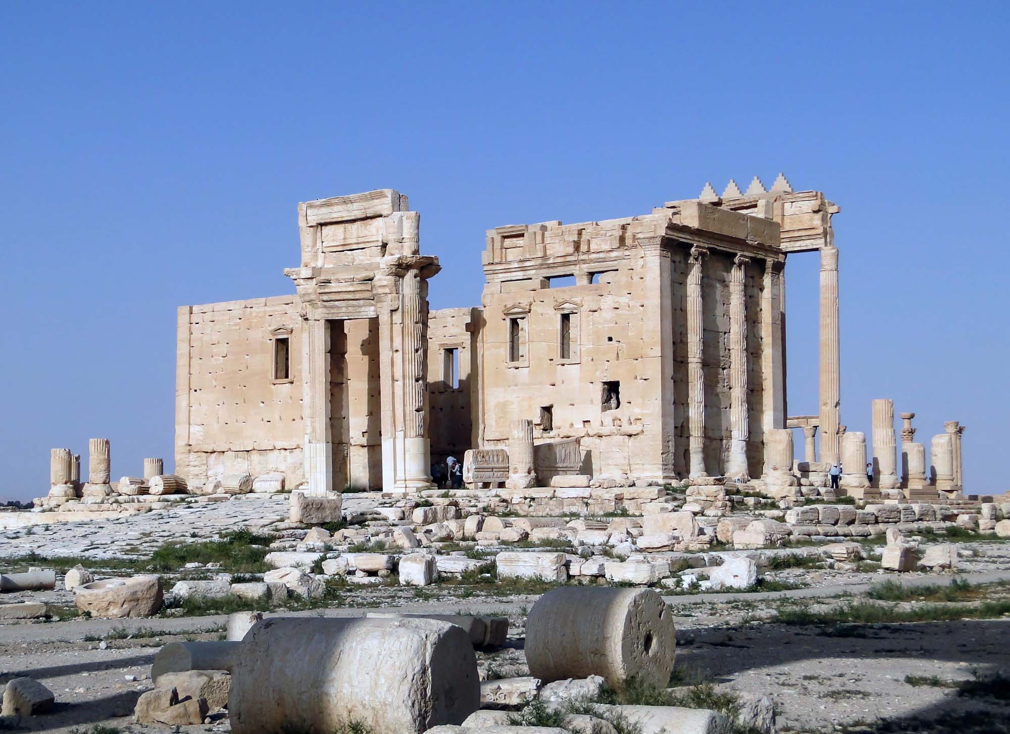 Photo of the stone ruins of a Roman temple. Many of the pillars and columns still stand, as does a portion of the front and side-facing walls.