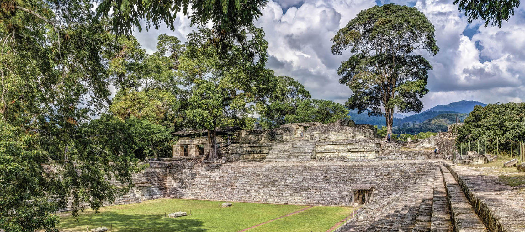 Photo of a field, surrounded by a great stone staircase. Above it are stone buildings.