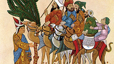 A painting of five adults and one small child. Four people are riding on the backs of camels, and they are wearing different colored robes. One person is standing and appears to be greeting them.