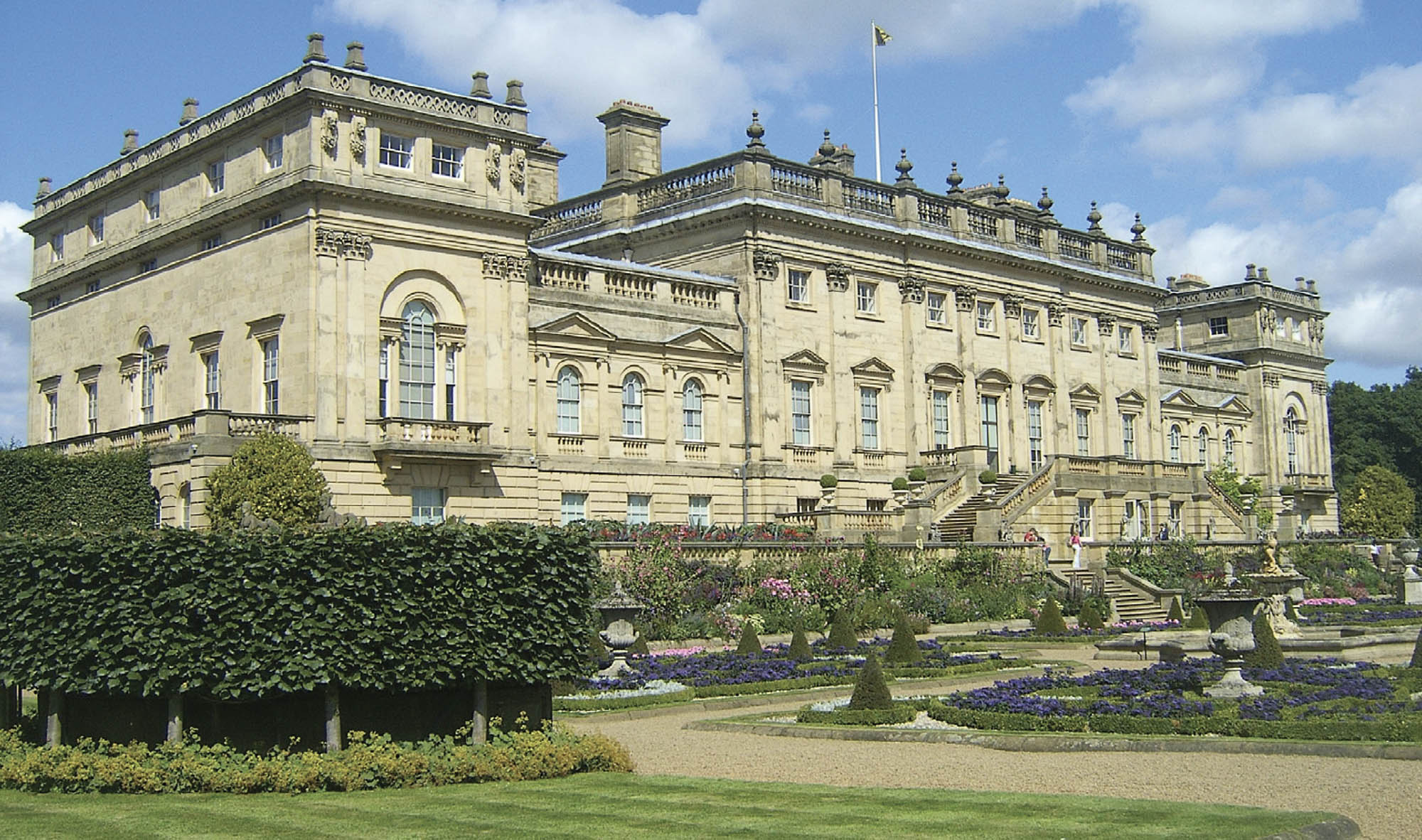 Photo of a very large stone building. The face of the building features many windows, carvings, and turrets.