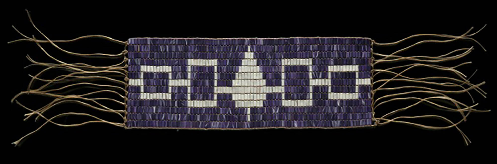 An elaborately woven and beaded belt  with long tassels.