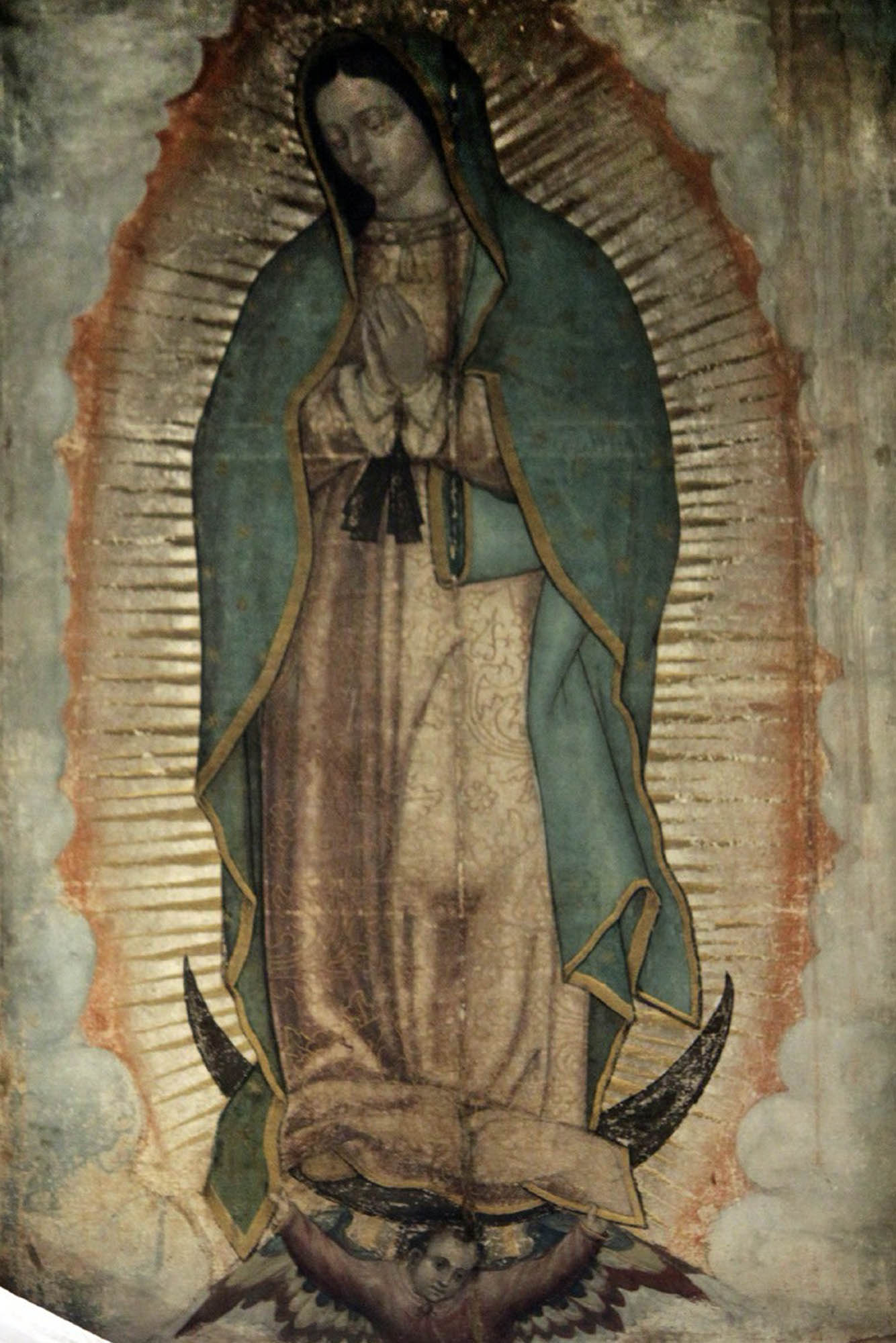 An image of the Virgin of Guadalupe who appears serene with hands in prayer and head bowed.