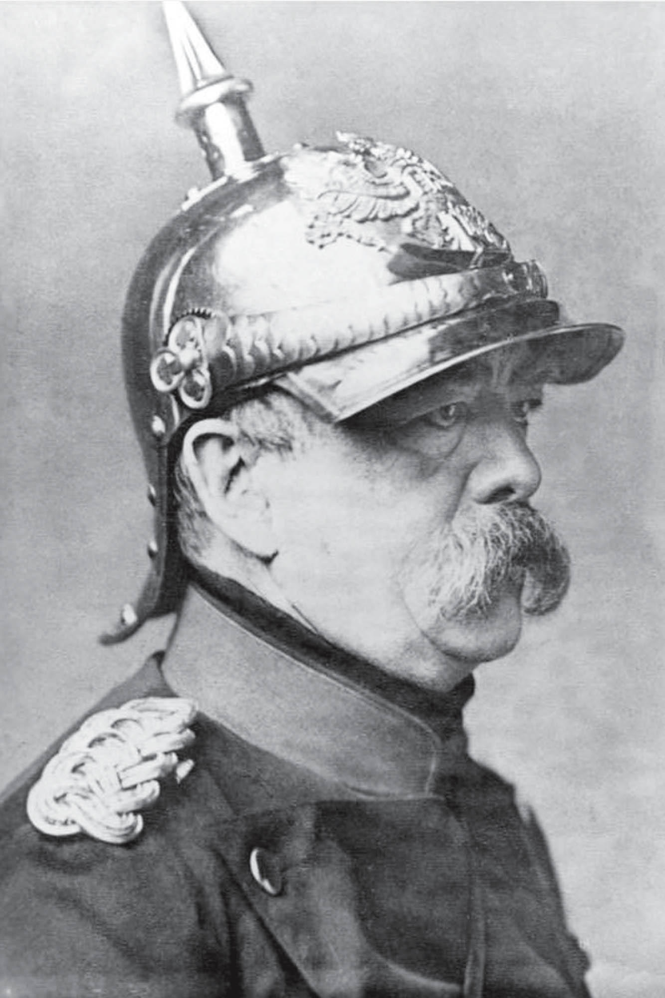 Black and white portrait of a serious-faced Otto von Bismarck with a prominent mustache and military uniform, facing right and wearing a helmet.
