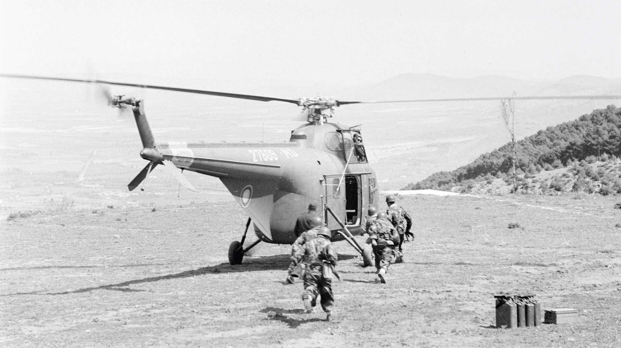 French soldiers run towards a waiting helicopter after a raid against Algerian rebels. 