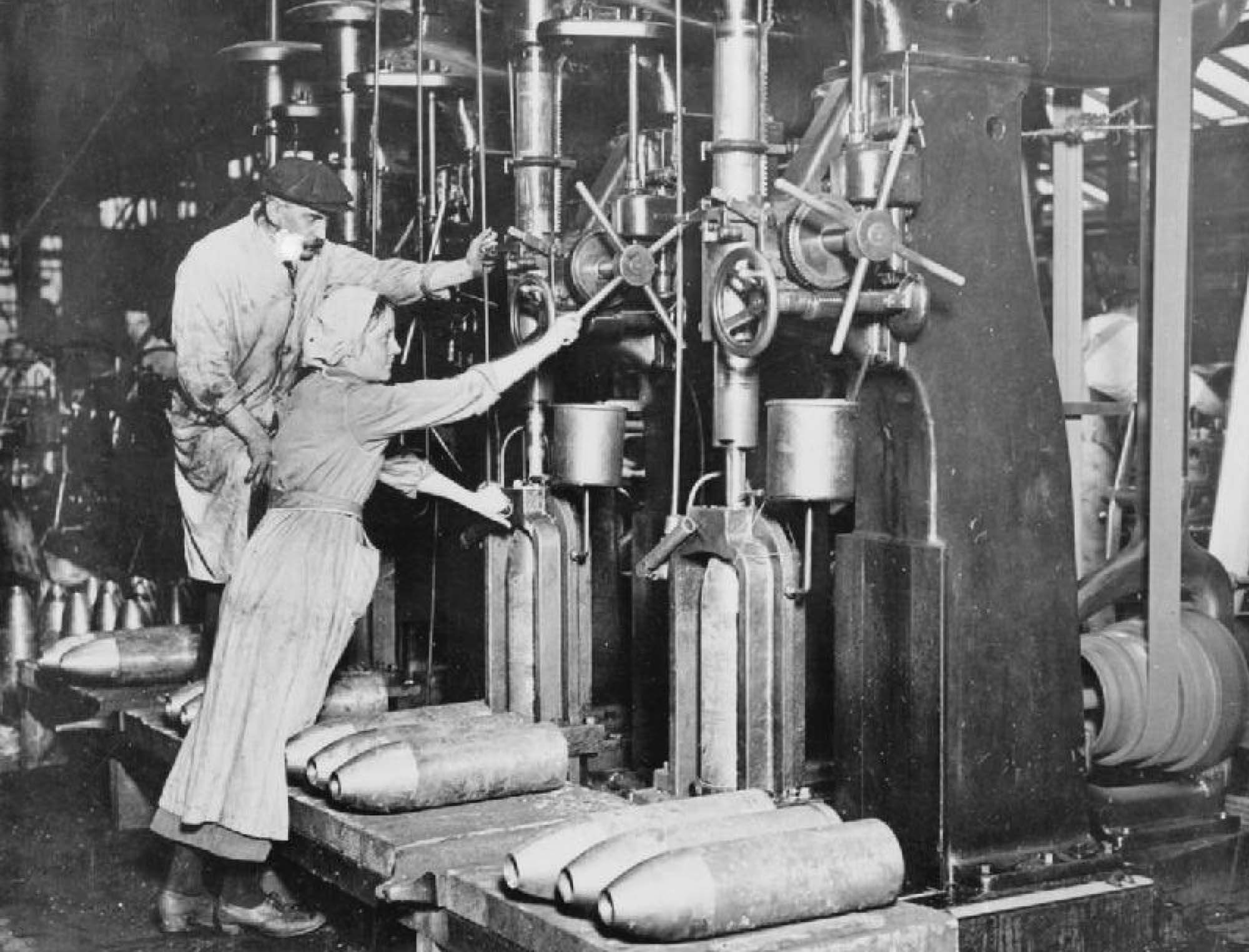 A photograph shows a man and a woman standing in front of a large industrial machine.