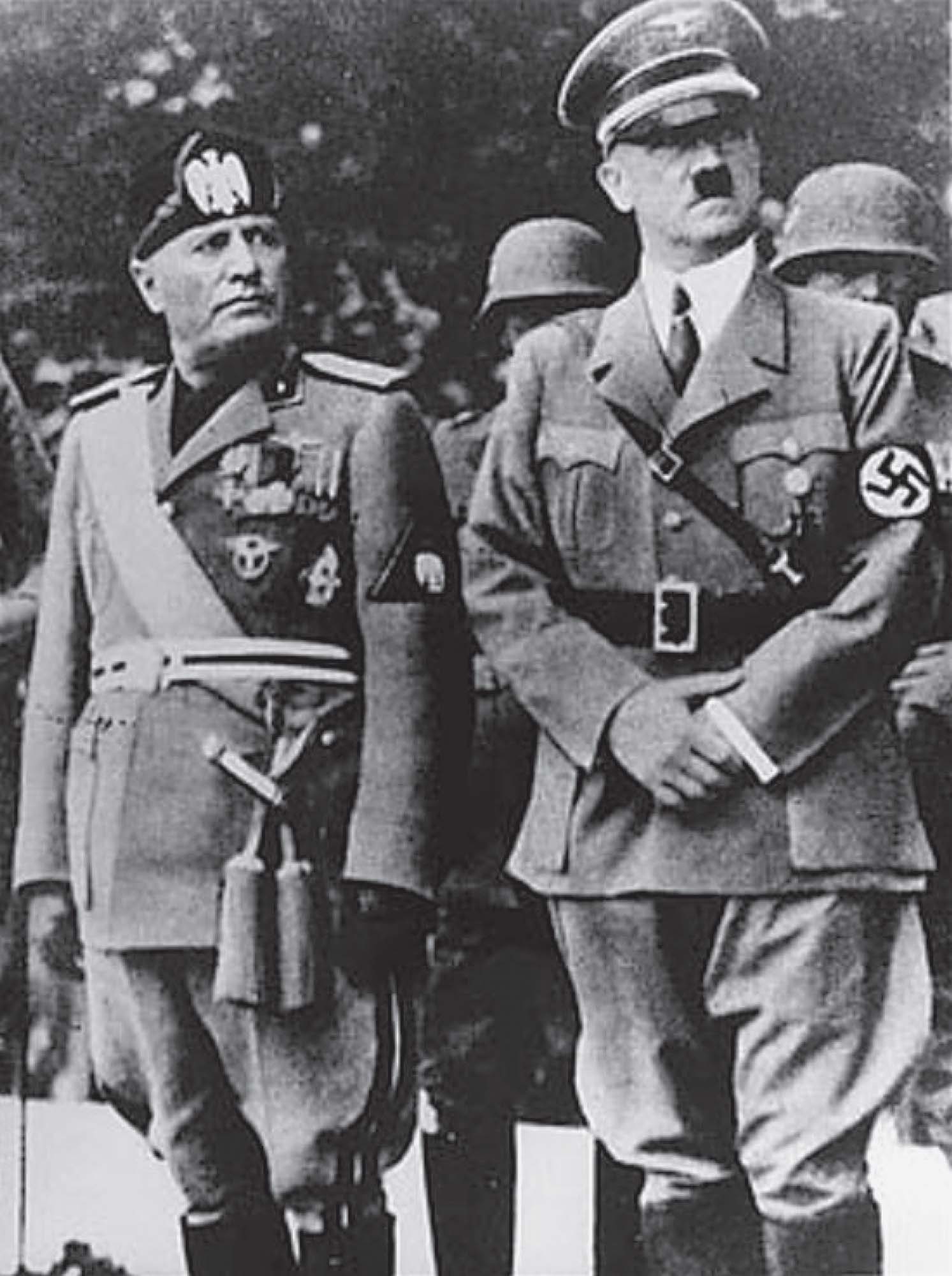 Photo of Mussolini and Hitler standing next to each other, each dressed in their military uniforms.