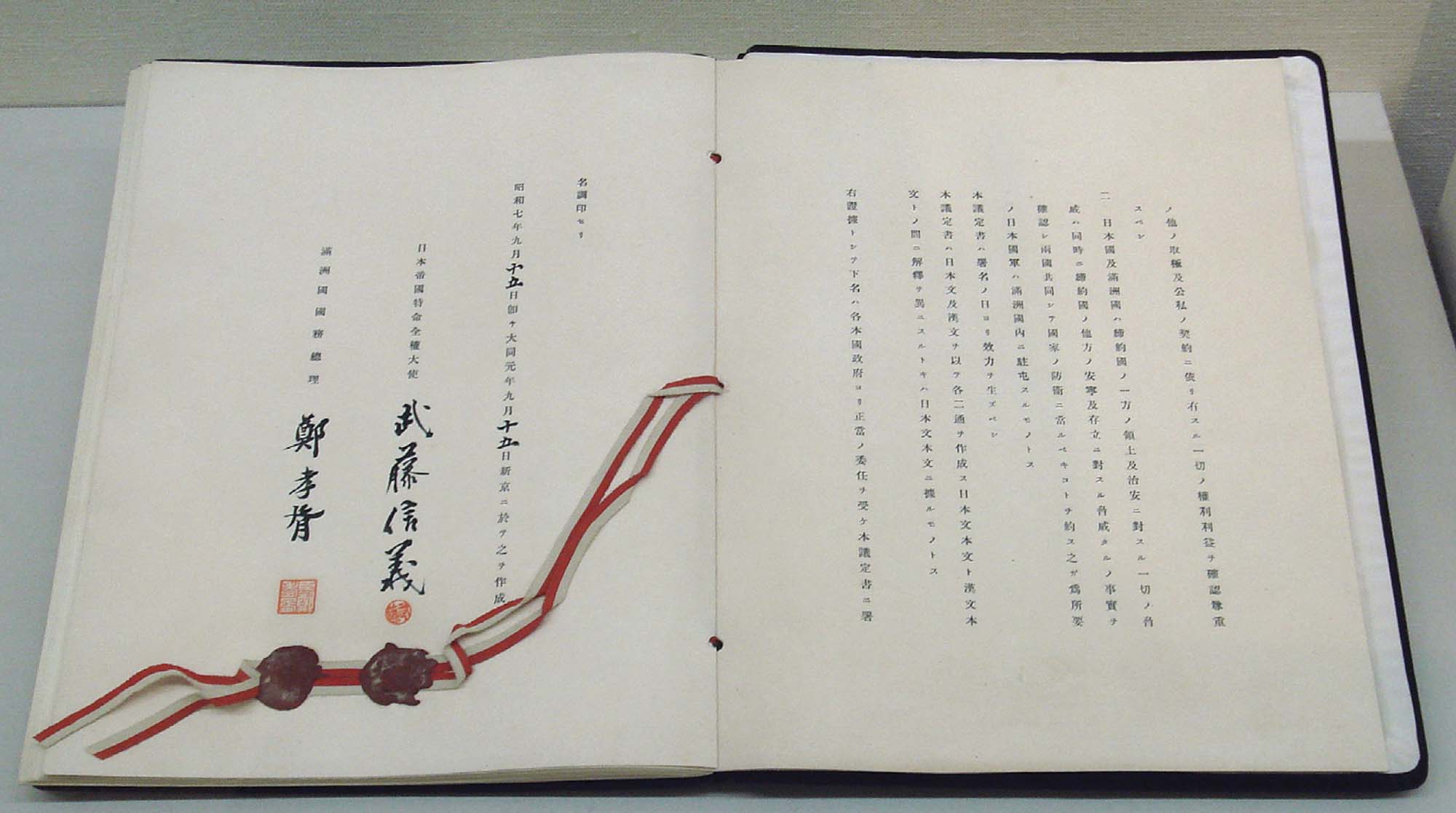Photo of the Japan-Manchukuo Protocol. Written in Japanese, two red stamps can be seen at the bottom of the left page.