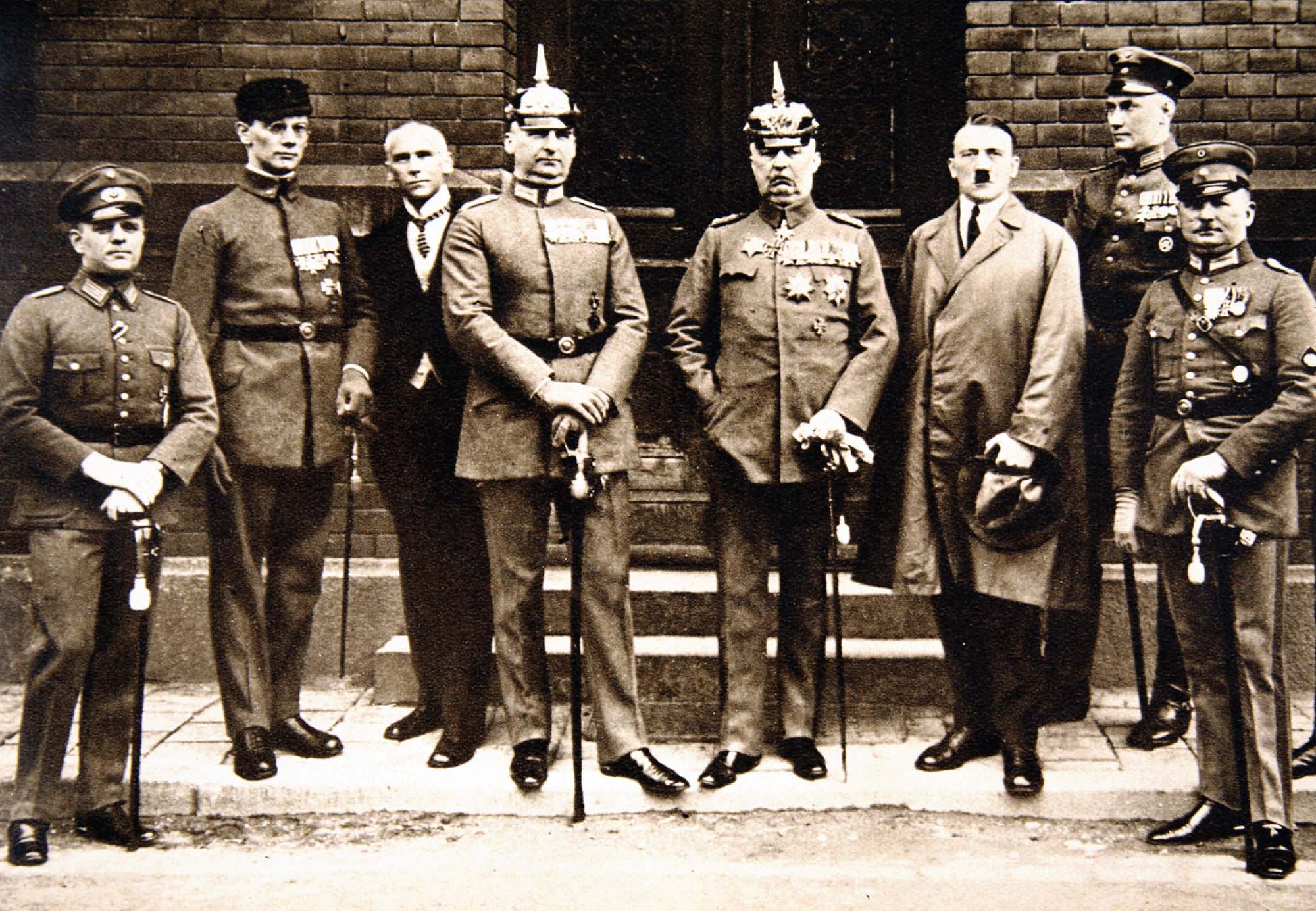 Photo of high-ranking members of the German military standing next to Adolf Hitler.