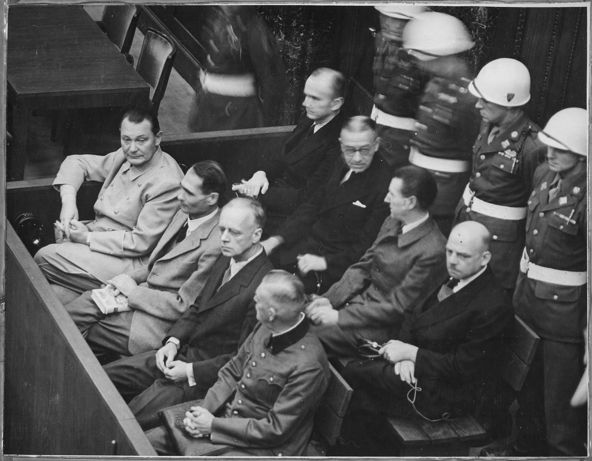 Photo of eight defendants sitting in their dock at the Nuremberg trials.