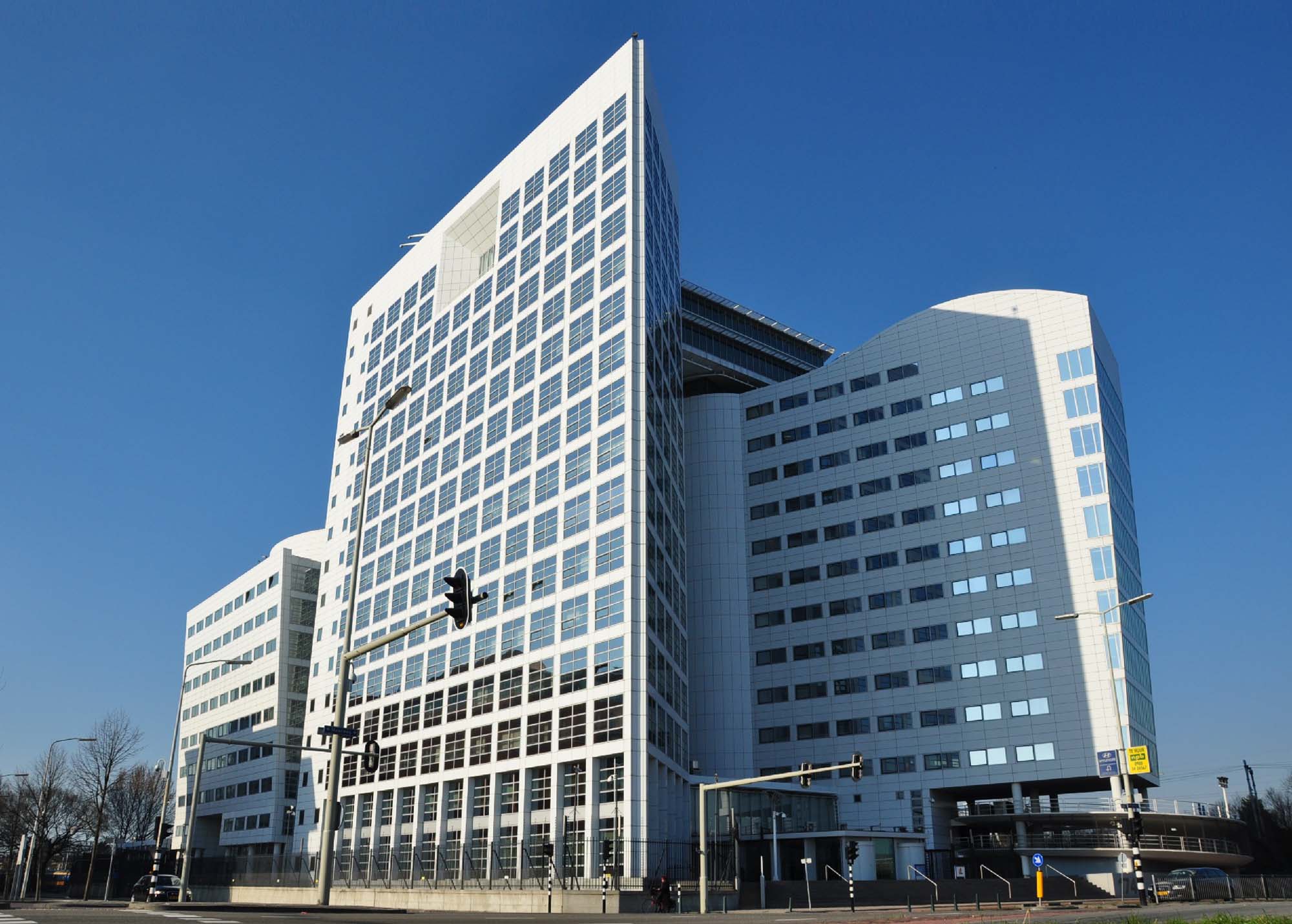 Photo depicting the outside of the International Criminal Court (ICC). The ICC is white in color and is lined with windows on all sides.