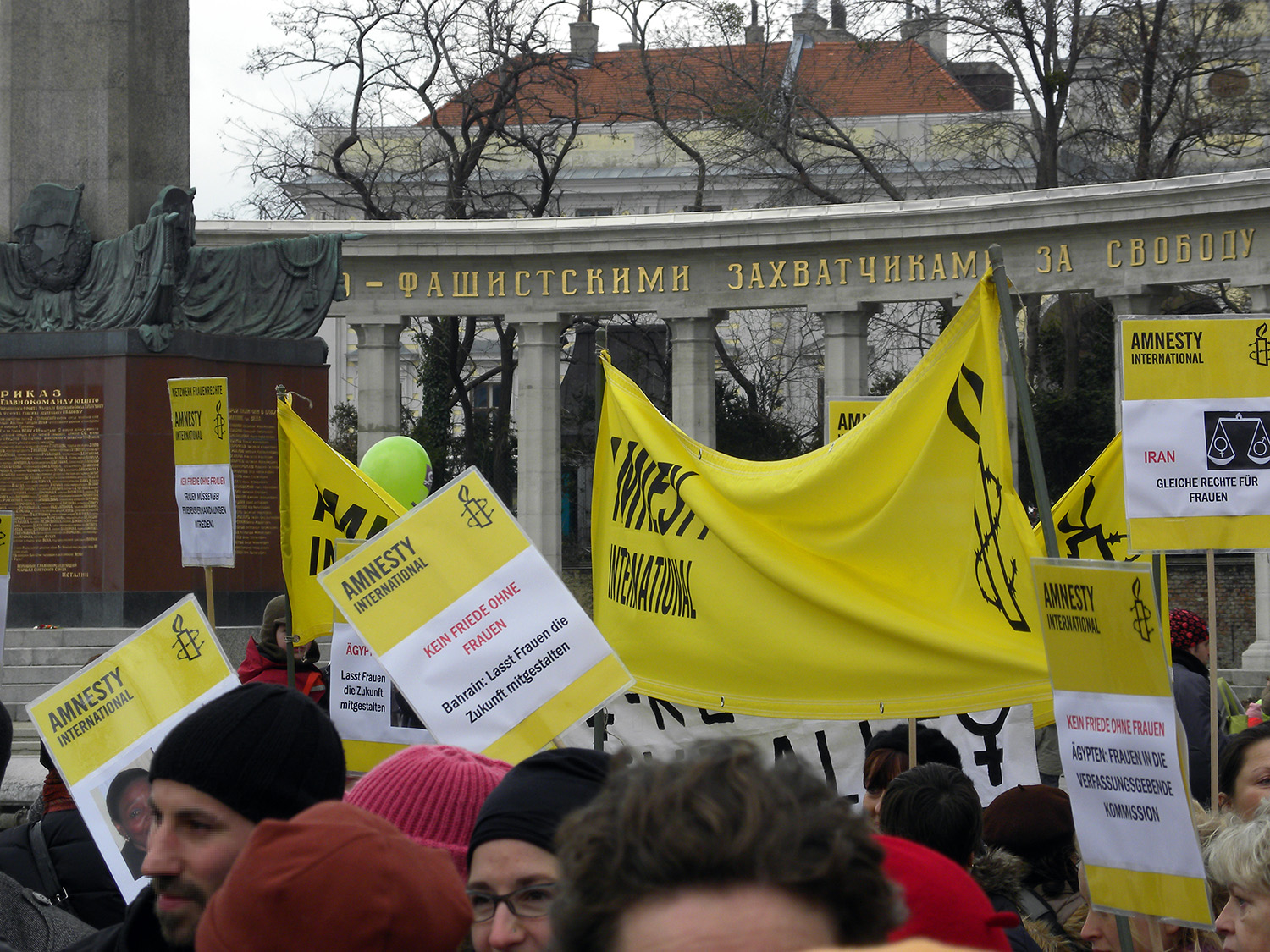 Street protest with marchers holding banners supporting International Women’s Day.