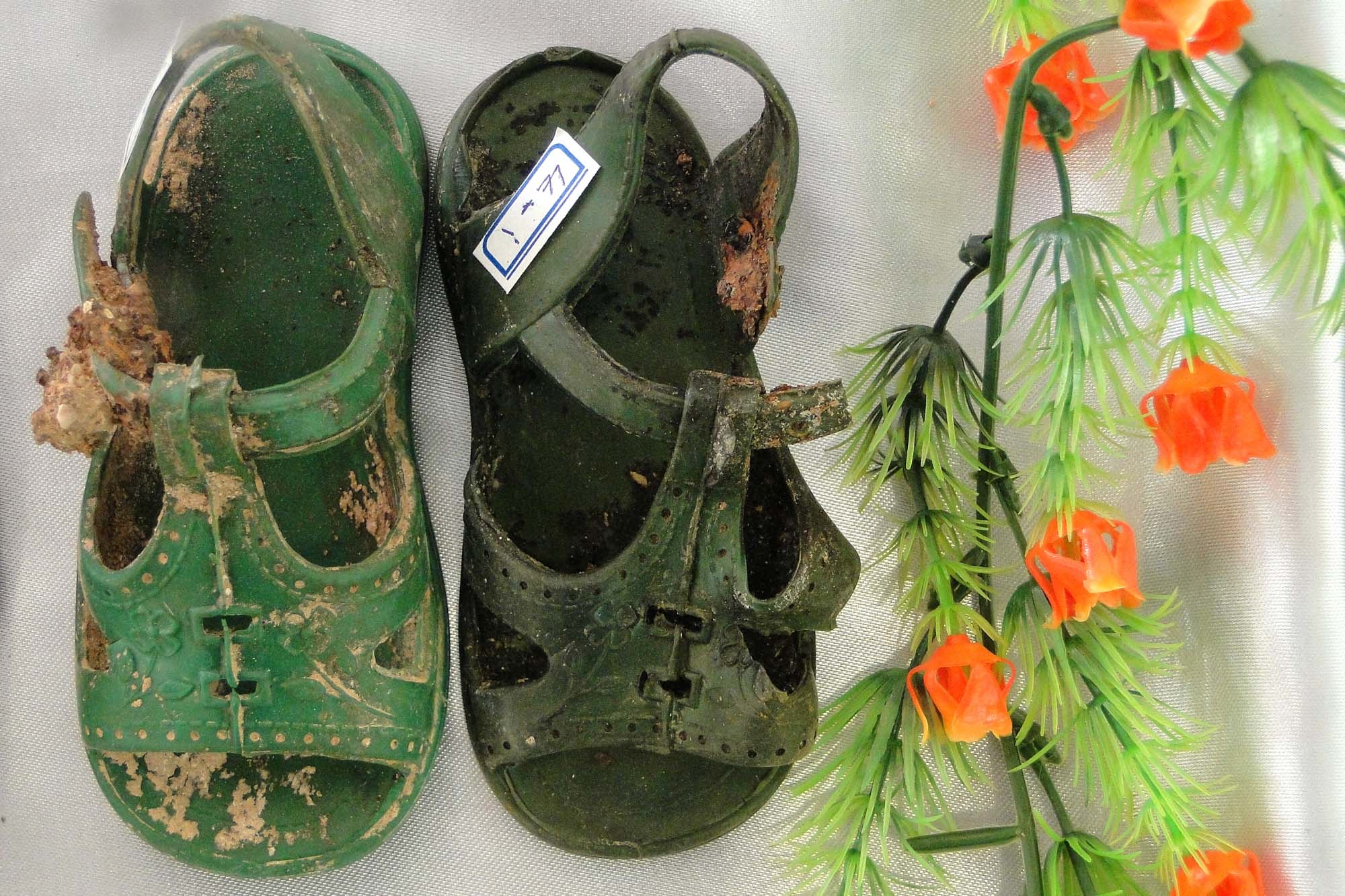 A photograph shows a pair of green, toddler sized sandals.