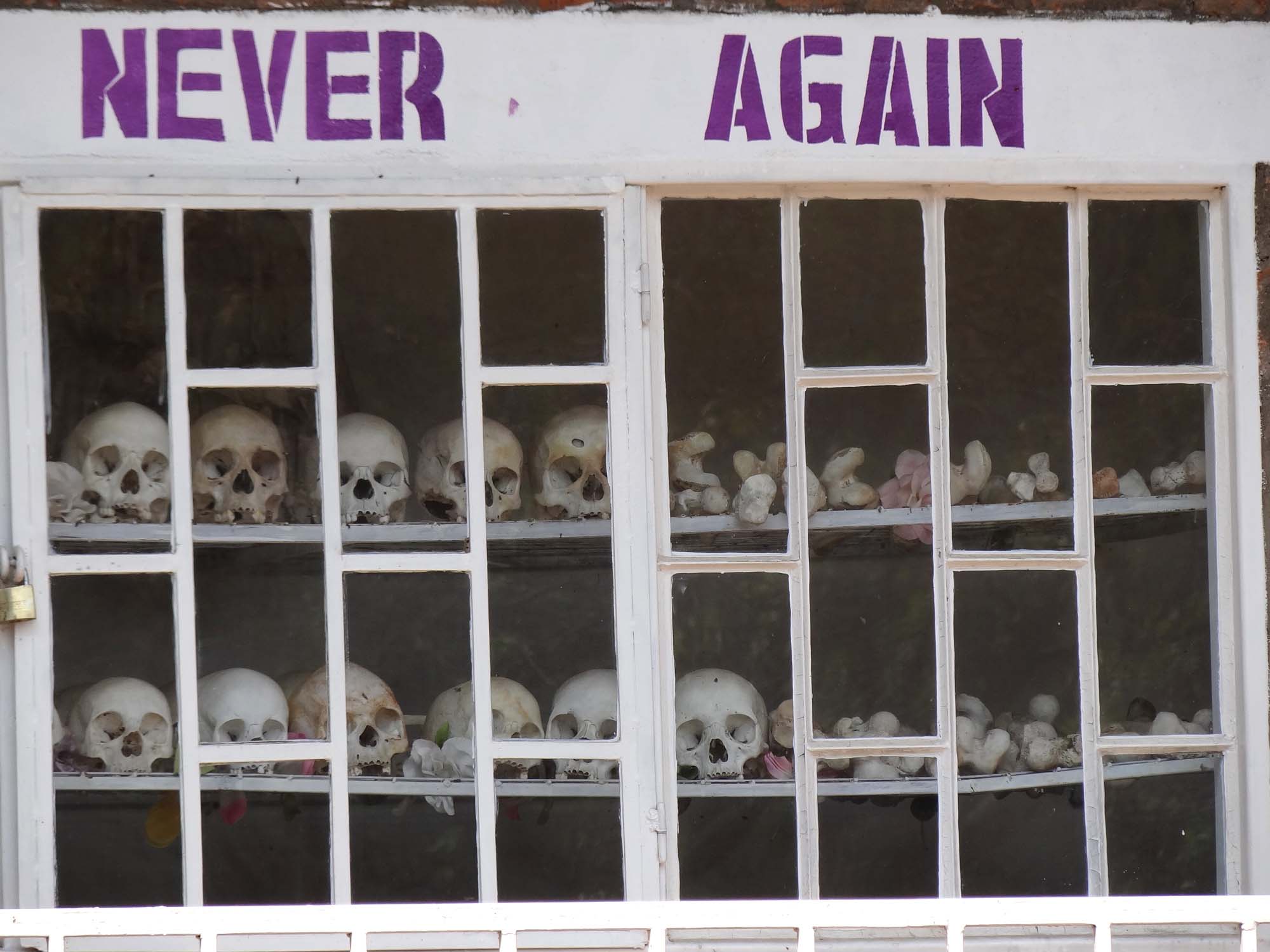 Behind a window, bordered with the words “NEVER AGAIN”, is a display of bones of the victims of Rwandan Genocide.